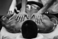 ספורטאי שוכב על הבטן ונהנה מעיסוי לשחרור שרירים
